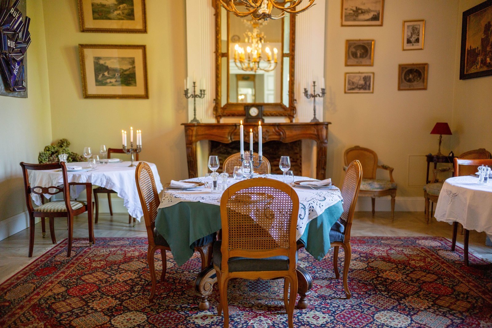 The manor dining room: fireplace, chandelier and laid tables