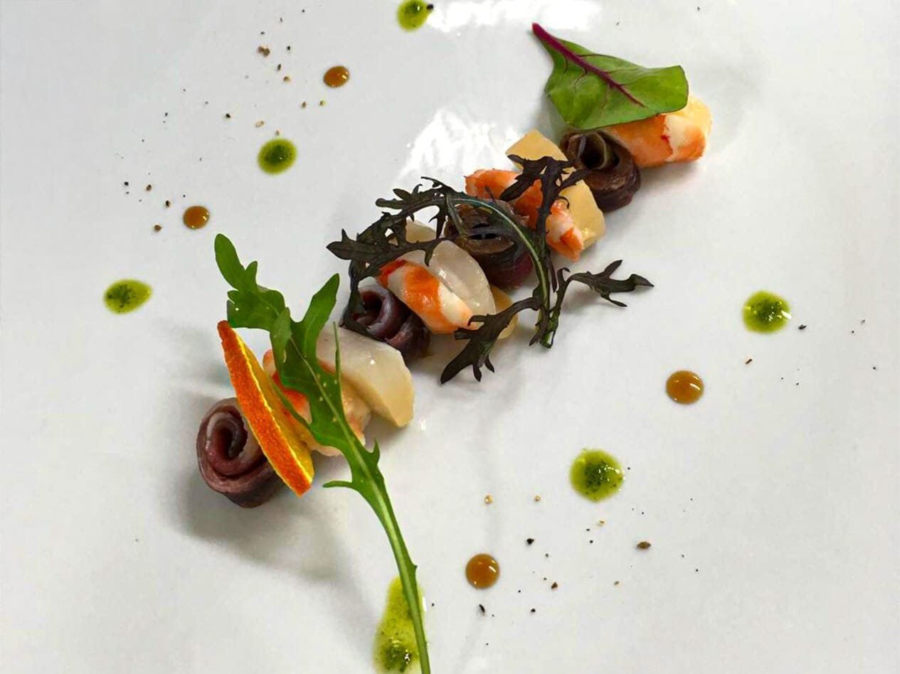 Entrée de saison dressée à l'assiette, légumes et herbes de saison